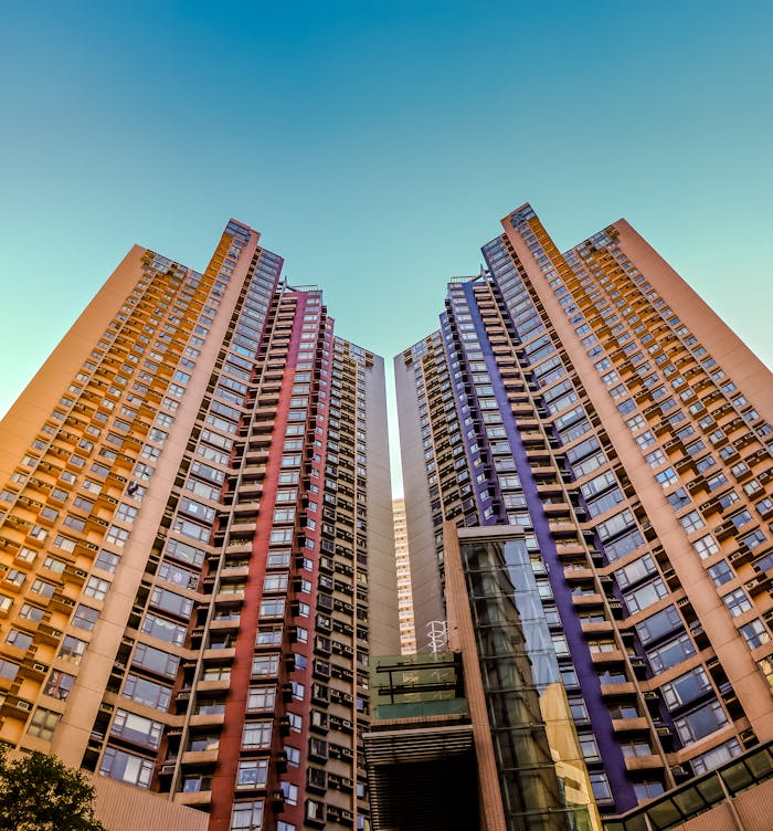 architectural-photography-of-buildings-1481105 Tall, colorful skyscrapers reaching into the blue sky in Hong Kong, showcasing modern architecture.